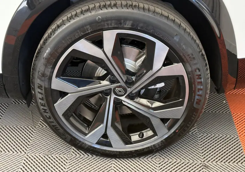 Gros plan sur la roue avant droite d’un Renault Espace blanc 2025, jante alliage noire et argent avec logo Renault central.