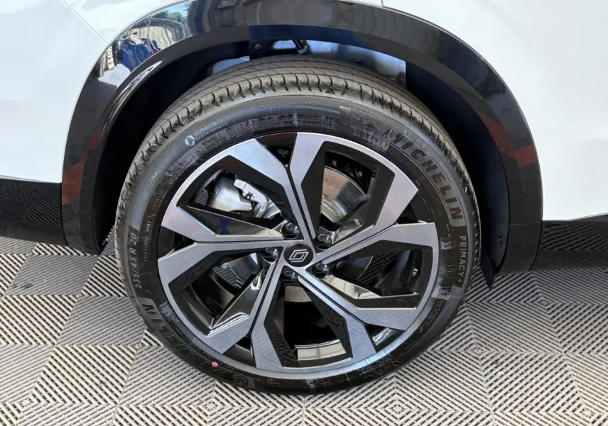 Gros plan sur la roue avant droite du Renault Espace blanc, jante alliage moderne bicolore et pneu Michelin.