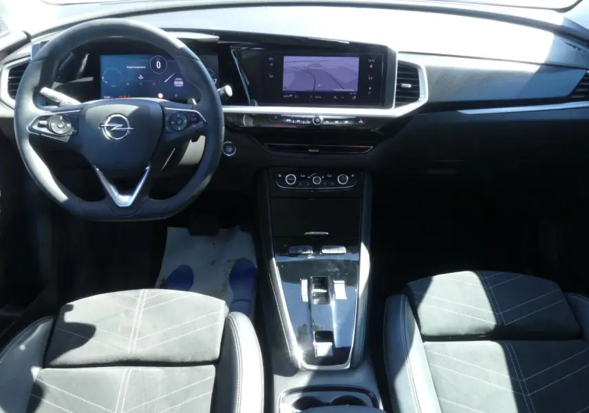 Vue intérieure frontale de l’Opel Grandland 2024 avec sellerie Alcantara noire et tableau de bord moderne.