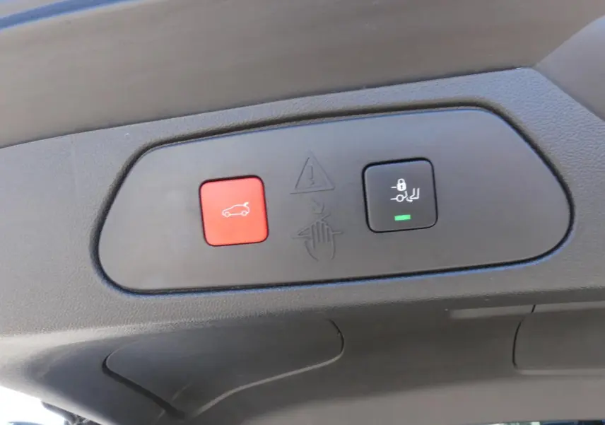 Gros plan sur les boutons du hayon motorisé mains-libres du toit intérieur d’un Opel Grandland blanc métallisé 2024.