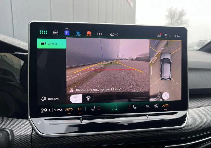 Écran tactile intérieur affichant la caméra 360° et vue arrière de la Volkswagen Golf VIII noire, tableau de bord moderne.