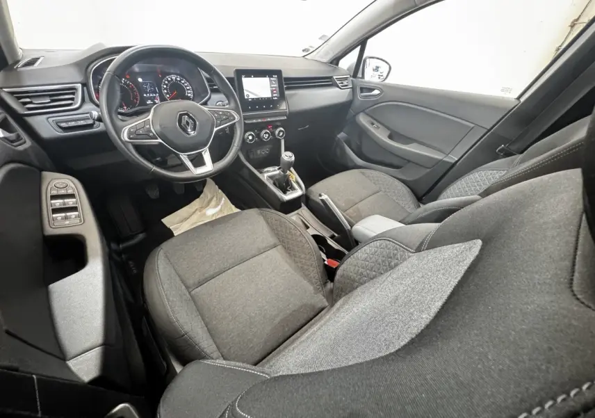 Vue intérieure côté conducteur de la Renault Clio Business TCe 100 2020, sièges tissu gris et tableau de bord avec écran tactile.