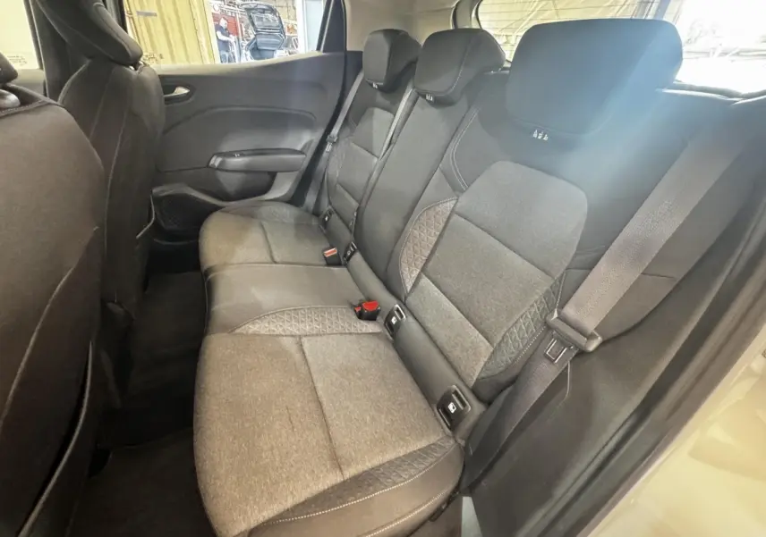 Vue intérieure côté droit sur la banquette arrière grise de la Renault Clio Business TCe 100 avec ceintures et appuie-têtes.