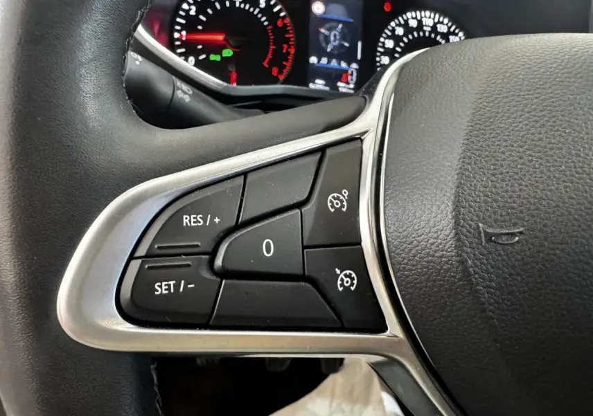 Gros plan sur le volant noir de la Renault Clio 2020, avec commandes de régulateur de vitesse visibles à gauche.