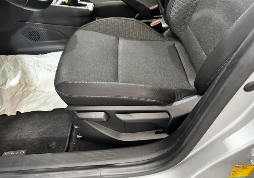 Vue rapprochée du siège avant droit gris foncé de la Renault Clio Business TCe 100, avec porte ouverte côté droit.
