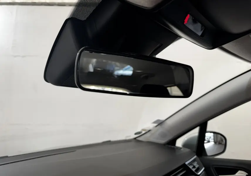 Vue intérieure du rétroviseur central et partie du tableau de bord de la Renault Clio Business TCe 100 gris clair de 2020.