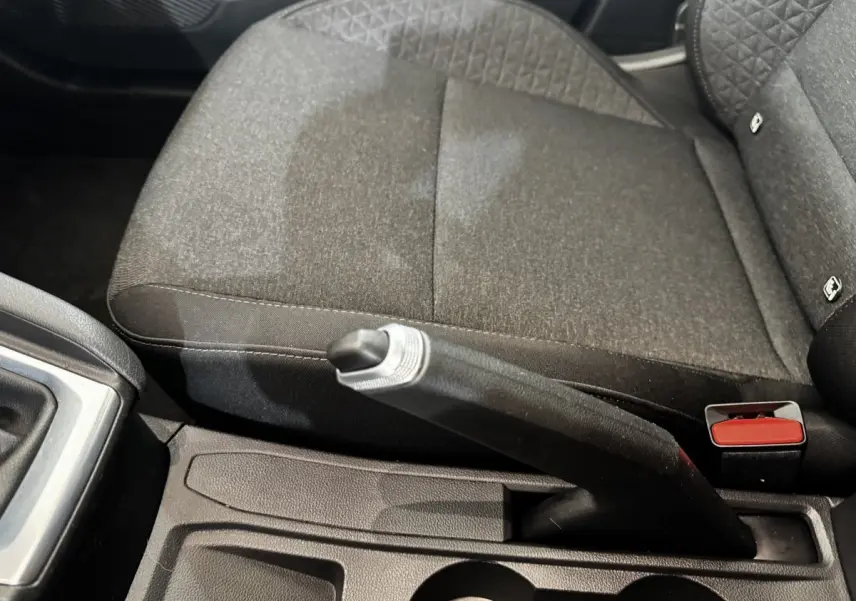 Gros plan sur le frein à main et la console centrale, siège tissu gris foncé de la Renault Clio Business TCe 100 2020.