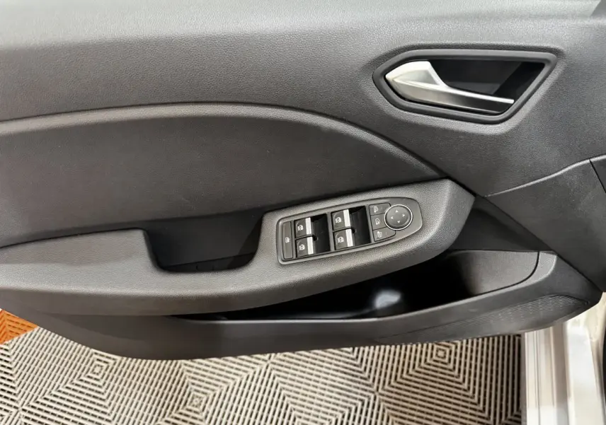 Vue rapprochée de la porte côté conducteur de la Renault Clio Business TCe 100 2020 avec commandes de vitres électriques et poignée grise.