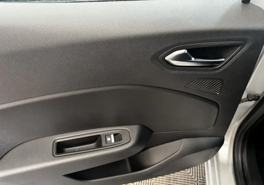 Vue intérieure côté droit de la porte avant grise claire de la Renault Clio avec poignée argentée et commande de fenêtre.