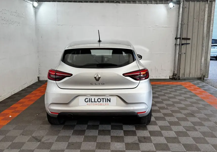Vue arrière d'une Renault Clio gris clair 2020 garée en intérieur avec feux arrière LED allumés.