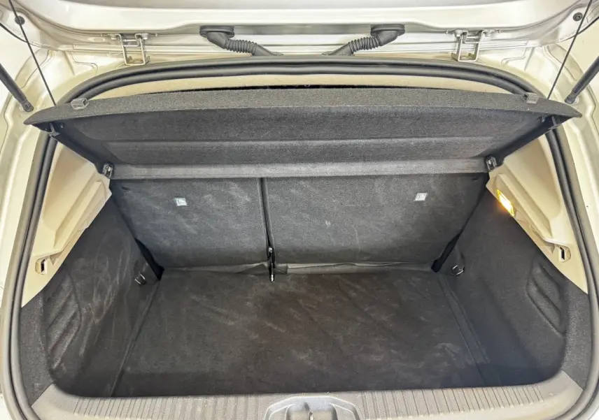 Coffre ouvert de Renault Clio Business gris clair, vue arrière montrant l'espace de chargement vide et la tablette cache-bagages.