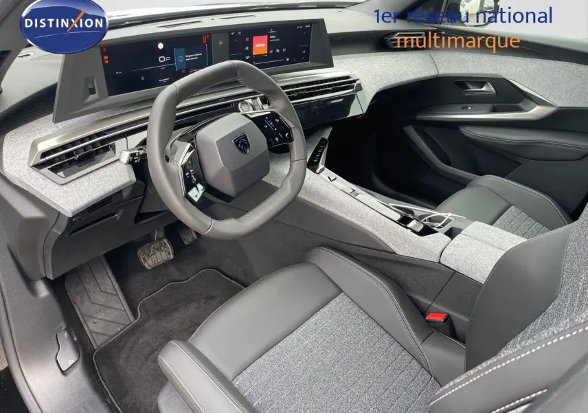 Intérieur avant droit du Peugeot 3008 Hybrid 2025 avec tableau de bord numérique et sellerie tissu gris et cuir noir.