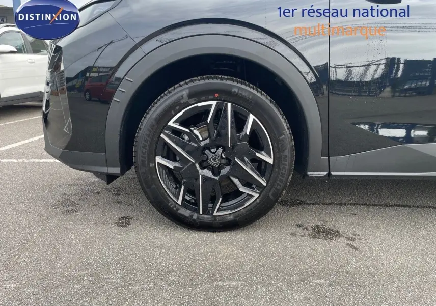 Gros plan sur la roue avant gauche du Peugeot 3008 noir perle métal, soulignant la jante alliage bicolore moderne.
