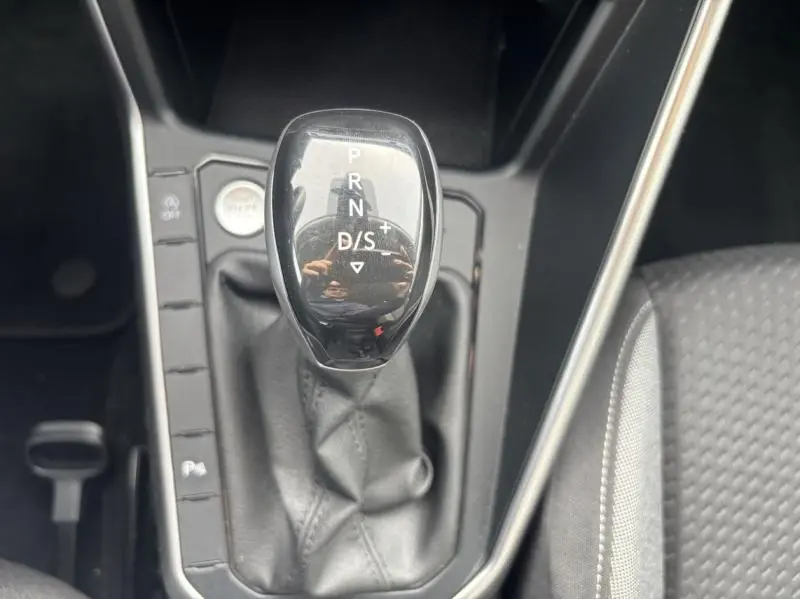 Le levier de vitesses automatique noir brillant du Volkswagen Taigo 2025 vu de dessus avec coutures apparentes.
