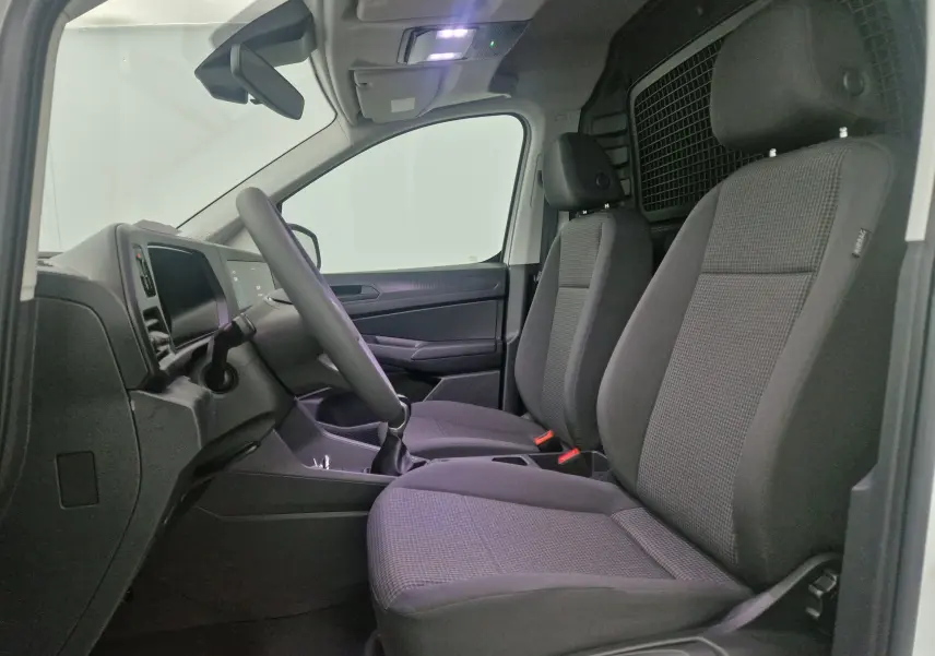 Vue arrière ouverte du Volkswagen Caddy Maxi blanc montrant l'espace de chargement vide avec roue de secours fixée à droite.