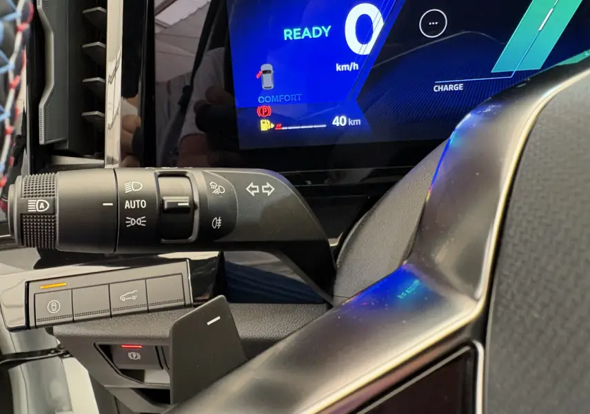 Gros plan sur la commande des feux et clignotants à gauche du volant dans un Renault Espace blanc 2025 esprit Alpine.