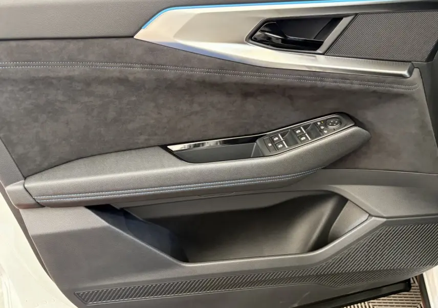 Gros plan sur la porte avant gauche blanche du Renault Espace 2025, avec garniture noire et commandes de vitres.