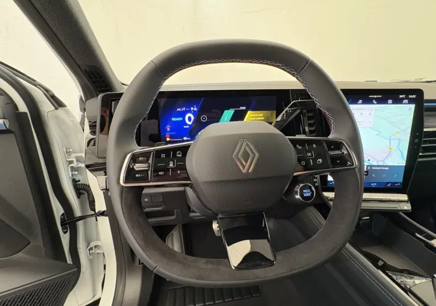 Vue intérieure centrée sur le volant en suède noir et les écrans digitaux du tableau de bord d’un Renault Espace blanc 2025.