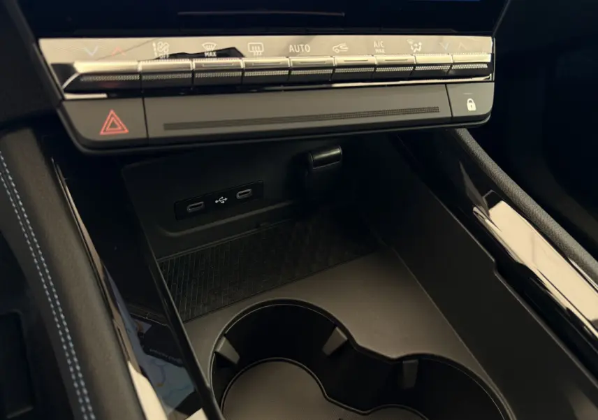Gros plan sur la console centrale noire du Renault Espace 2025, avec ports USB-C et commandes climatisation tactiles.