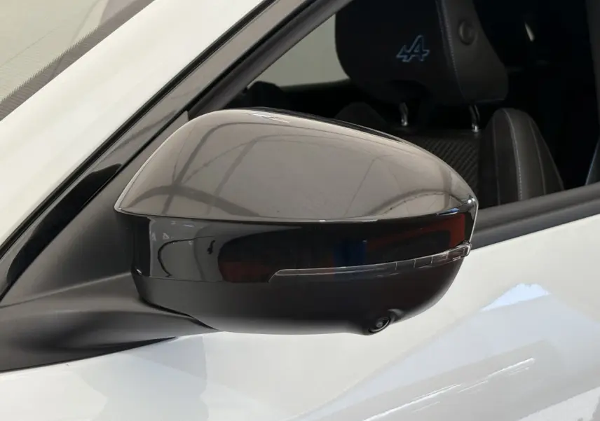 Rétroviseur extérieur droit noir brillant sur Renault Espace blanc esprit Alpine, avec siège avant brodé logo Alpine visible.