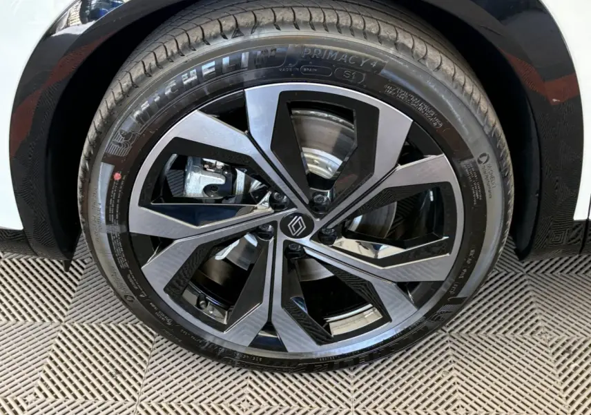 Gros plan sur la roue avant droite du Renault Espace blanc, jante alliage noire et argentée au design moderne.