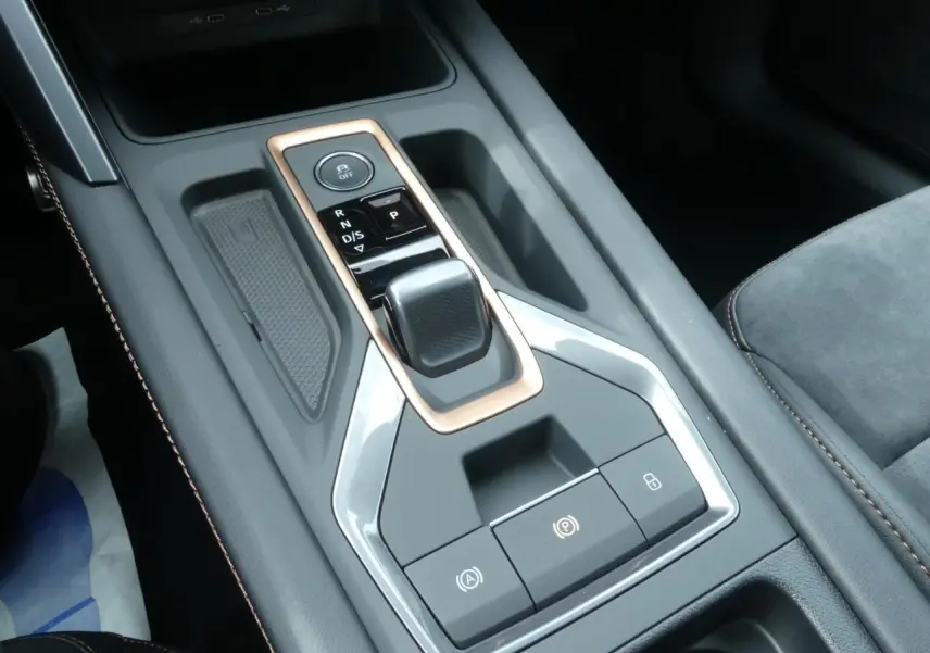 Gros plan sur la console centrale du CUPRA Formentor gris magnétique, avec levier de vitesses et surpiqûres cuivrées.