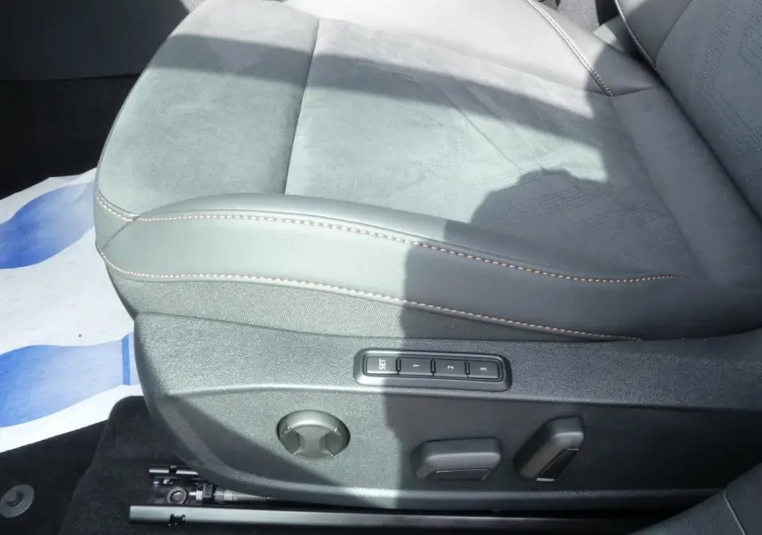 Gros plan sur le siège conducteur gris suédine avec surpiqûres cuivrées et commandes électriques mémoire du Cupra Formentor 2025.