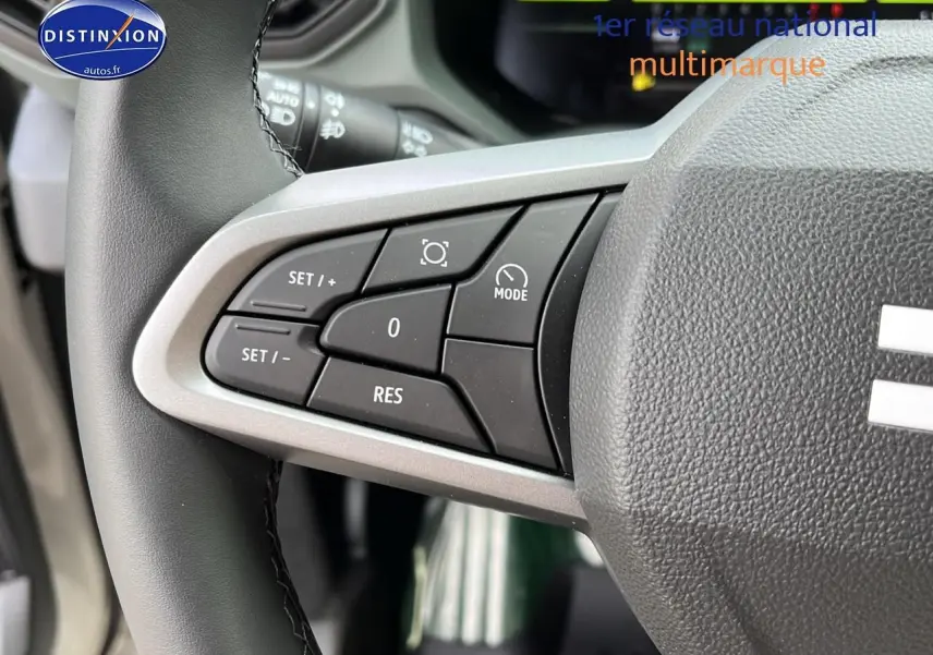 Gros plan sur les commandes multifonctions à gauche du volant du Dacia Duster 2025 couleur Sandstone.