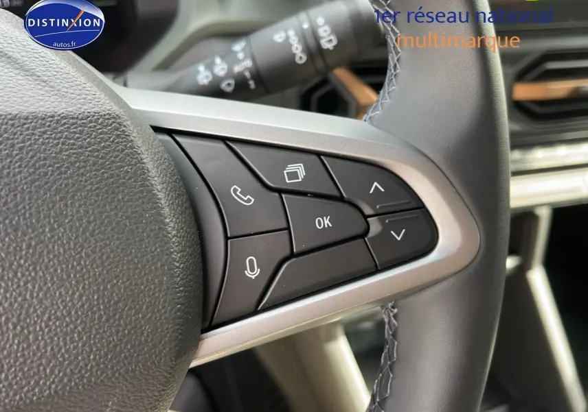 Gros plan sur les commandes multifonctions à droite du volant du Dacia Duster 2025, intérieur moderne et épuré.
