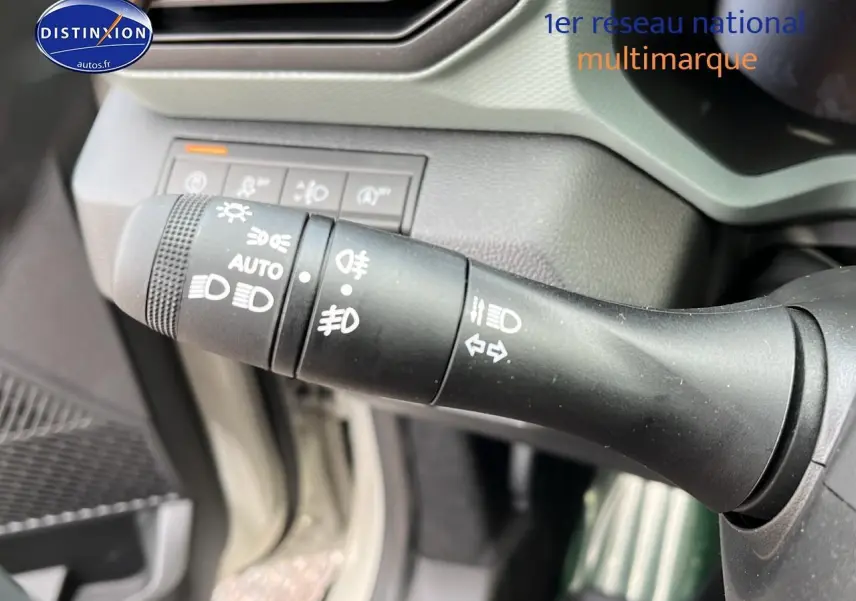 Gros plan sur la commande des feux et clignotants du Dacia Duster 2025, intérieur noir et gris.
