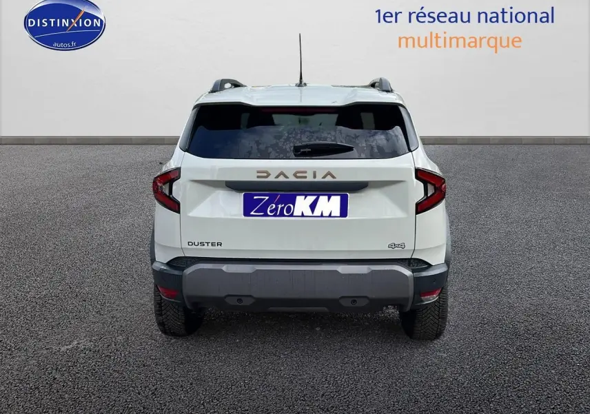 Vue arrière d'un Dacia Duster 2025 blanc avec logo DACIA en relief et feux arrière en forme de C.