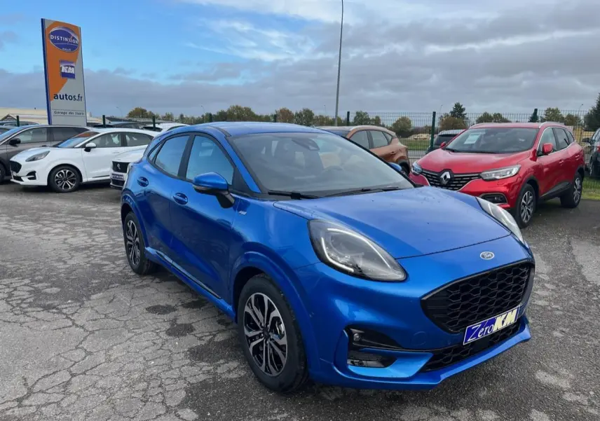 Ford Puma bleu métallisé en vue 3/4 avant droit, avec jantes alliage noires et calandre noire distinctive.