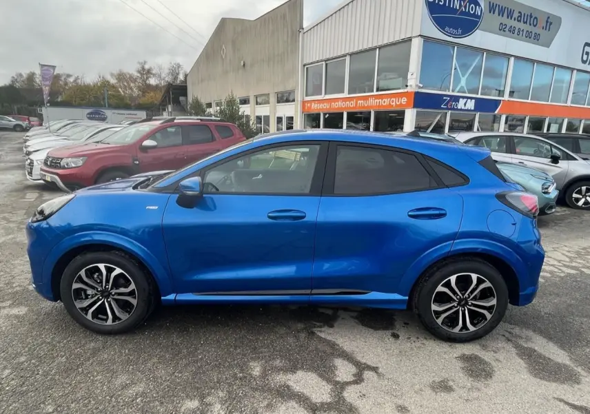 Profil côté gauche du Ford Puma bleu métallisé 2022 avec jantes alliage noires et badges ST-Line visibles.