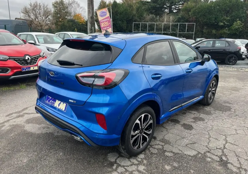 Vue 3/4 arrière droite d'un Ford Puma bleu métallisé avec jantes alliage noires et badges ST-Line visibles.