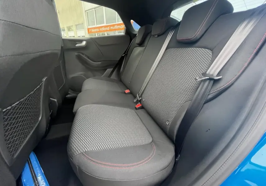 Vue intérieure arrière côté droit du Ford Puma bleu 2022, sièges tissu noir avec surpiqûres rouges.