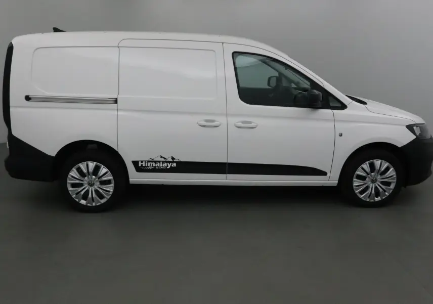 Profil droit d'un Volkswagen Caddy Maxi blanc avec logo Himalaya et jantes argentées dans un studio.