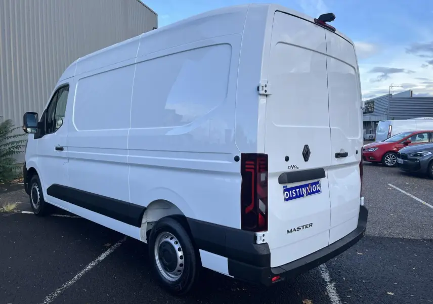 Renault Master blanc en vue 3/4 arrière droit, fourgon tôlé avec feux arrière verticaux et jantes tôle 16 pouces.