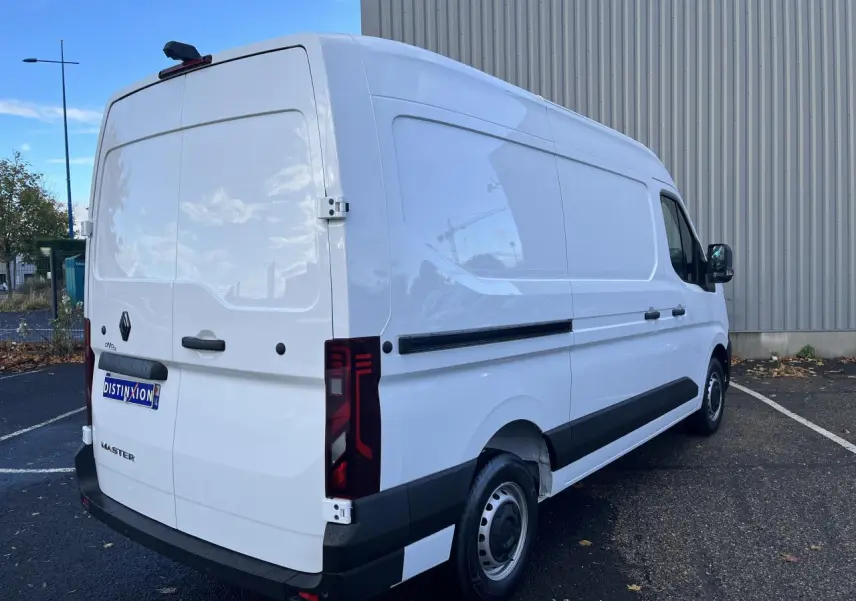 Vue 3/4 arrière droite du Renault Master blanc, fourgon tôlé avec feux arrière verticaux et jantes tôle.
