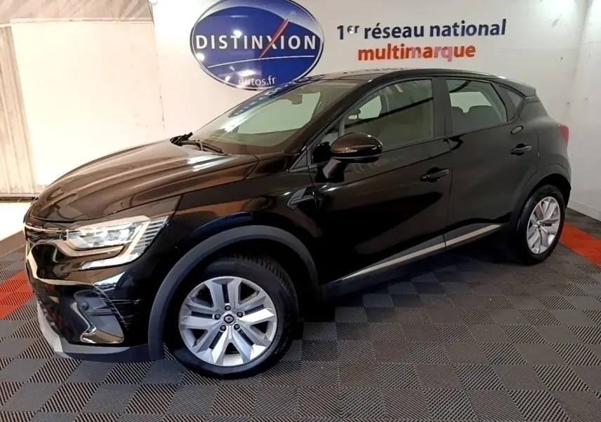 Renault Captur Business noir en 3/4 avant droit, avec jantes argentées et phares LED allumés en intérieur showroom.