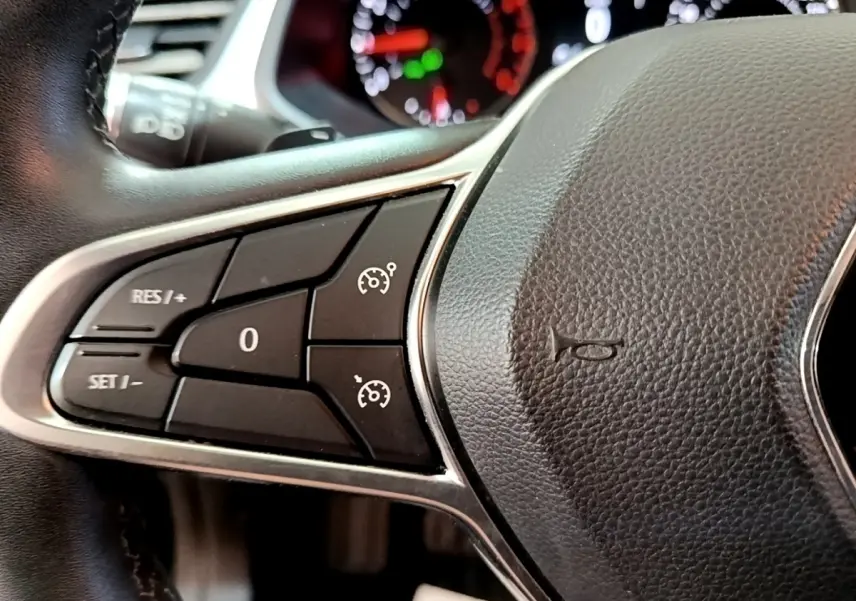 Gros plan sur le côté gauche du volant noir du Renault Captur 2021 avec commandes du régulateur de vitesse.