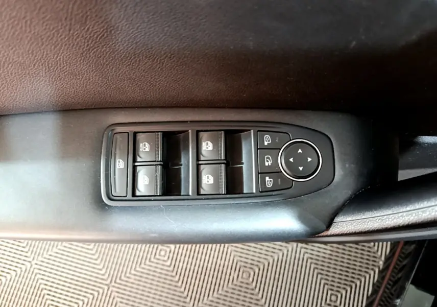 Gros plan sur les commandes des vitres électriques et rétroviseurs du côté conducteur du Renault Captur Business noir 2021.