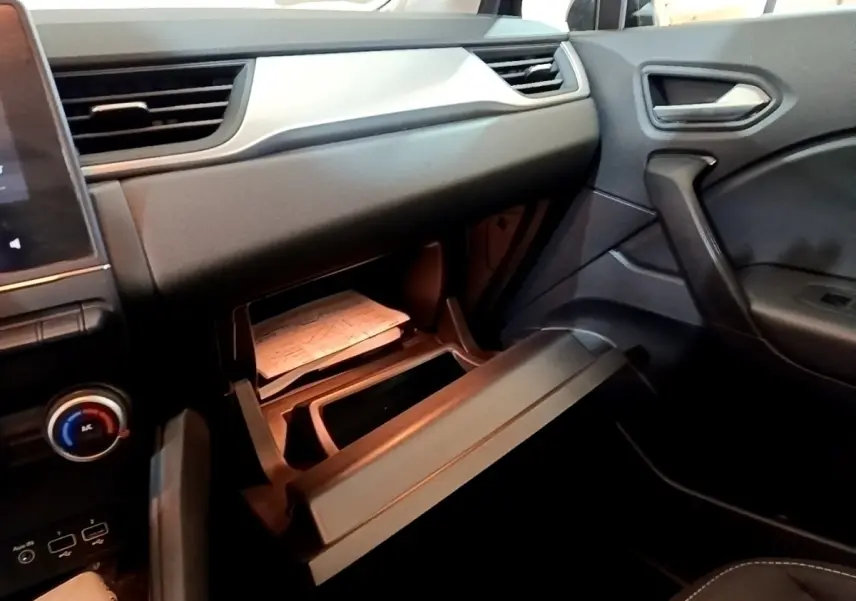 Intérieur Renault Captur Business 2021, vue côté passager sur boîte à gants ouverte et tableau de bord noir.