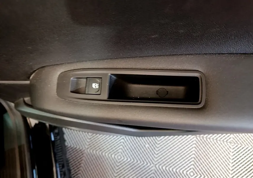 Détail de la commande de verrouillage centralisé sur la porte intérieure côté gauche du Renault Captur noir Business 2021.