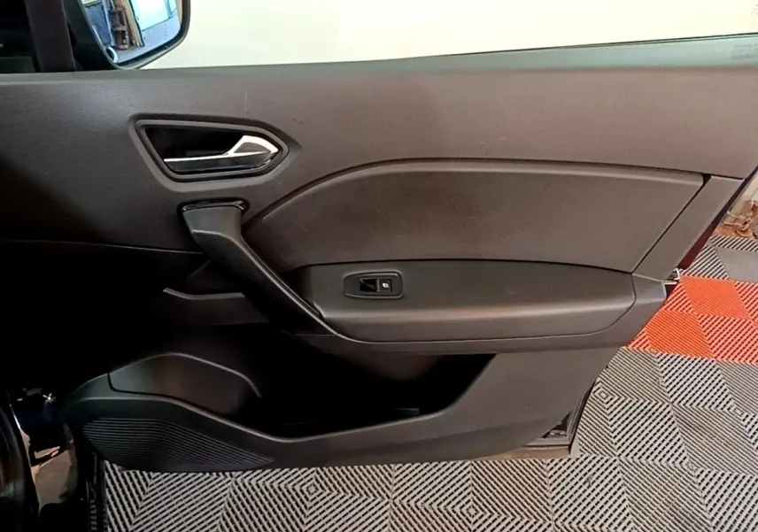 Vue intérieure côté gauche de la porte noire du Renault Captur 2021 avec poignée et commande de vitre électrique.