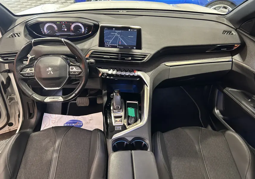 Vue intérieure frontale du tableau de bord et volant du Peugeot 3008 blanc, avec écran tactile et console centrale moderne.
