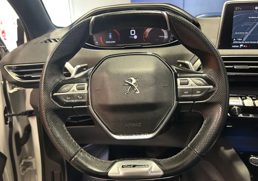 Vue rapprochée du volant cuir perforé noir avec logo Peugeot et commandes intégrées du Peugeot 3008 GT Line 2020.