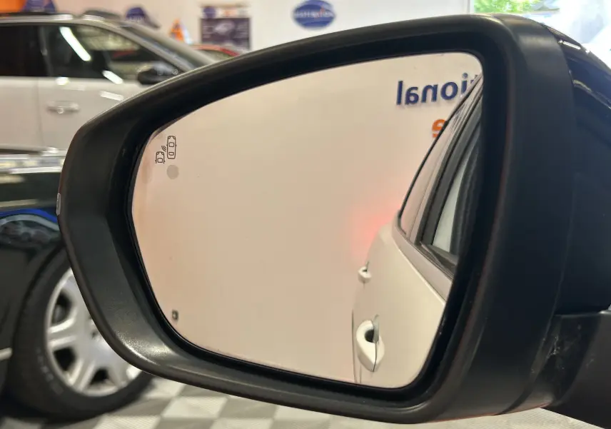 Rétroviseur extérieur droit montrant la partie arrière blanche d’un Peugeot 3008 GT Line avec poignée de porte visible.