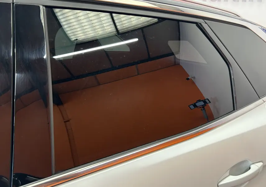 Gros plan sur la porte arrière droite blanche d’un Peugeot 3008 2020 avec vitres teintées et toit ouvrant visible.