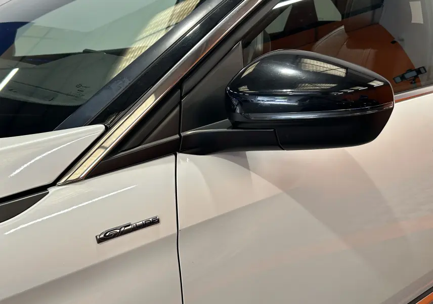 Gros plan sur le rétroviseur noir et l’emblème GT Line côté gauche d’un Peugeot 3008 blanc.