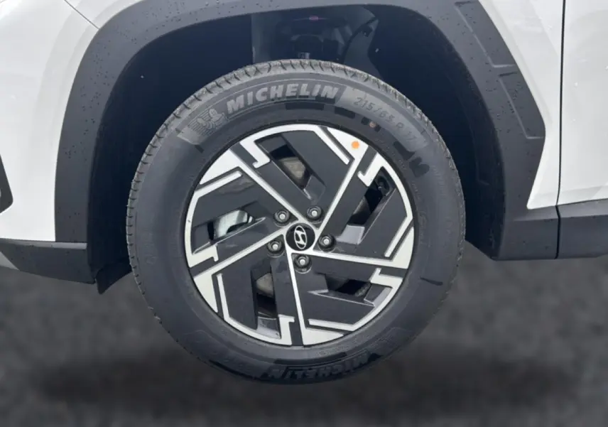 Gros plan sur la roue avant droite blanche du Hyundai Tucson 2026 avec jante alliage noire et argentée signée Hyundai.